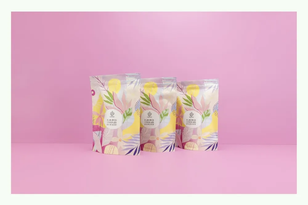 Four colourful stand-up pouches with plant design against pink background Four colourful stand-up pouches with plant design against pink background