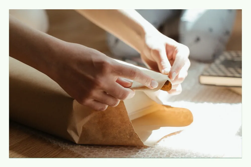 Hands folding brown paper for packaging Hands folding brown paper for packaging