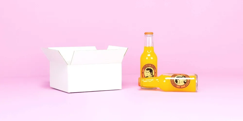 Kleine unbedruckte Versandbox vor rosa Hintergrund Kleine unbedruckte Versandbox vor rosa Hintergrund