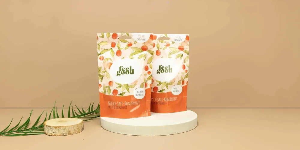 Zwei bedruckte Doypack Beutel vor einem beigen Hintergrund Zwei bedruckte Doypack Beutel vor einem beigen Hintergrund